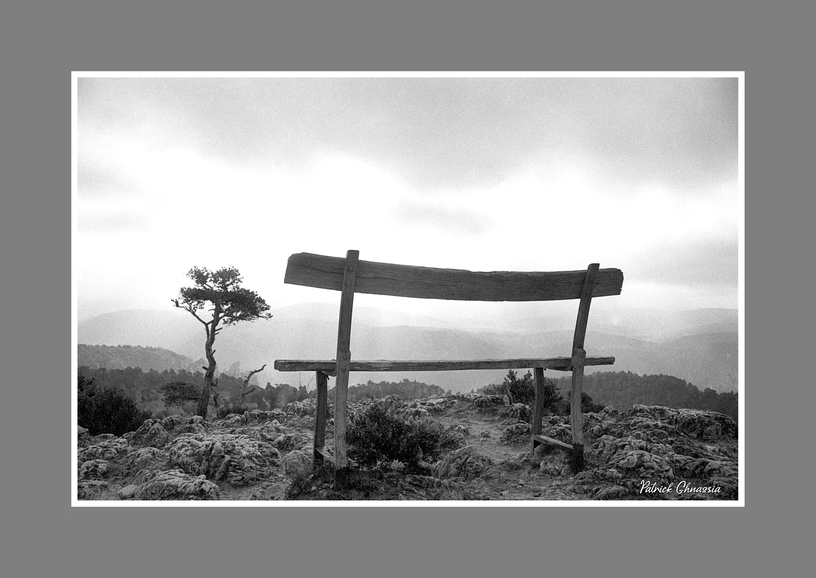 Un banc de bois vide face à l'horizon brumeux des Cévennes · photographie de Patrick Ghnassïa, 1974